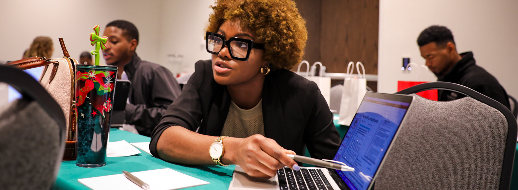 Woman pointing to information on a laptop.